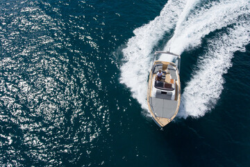 Drone top view of a small luxury boat sailing at high speed