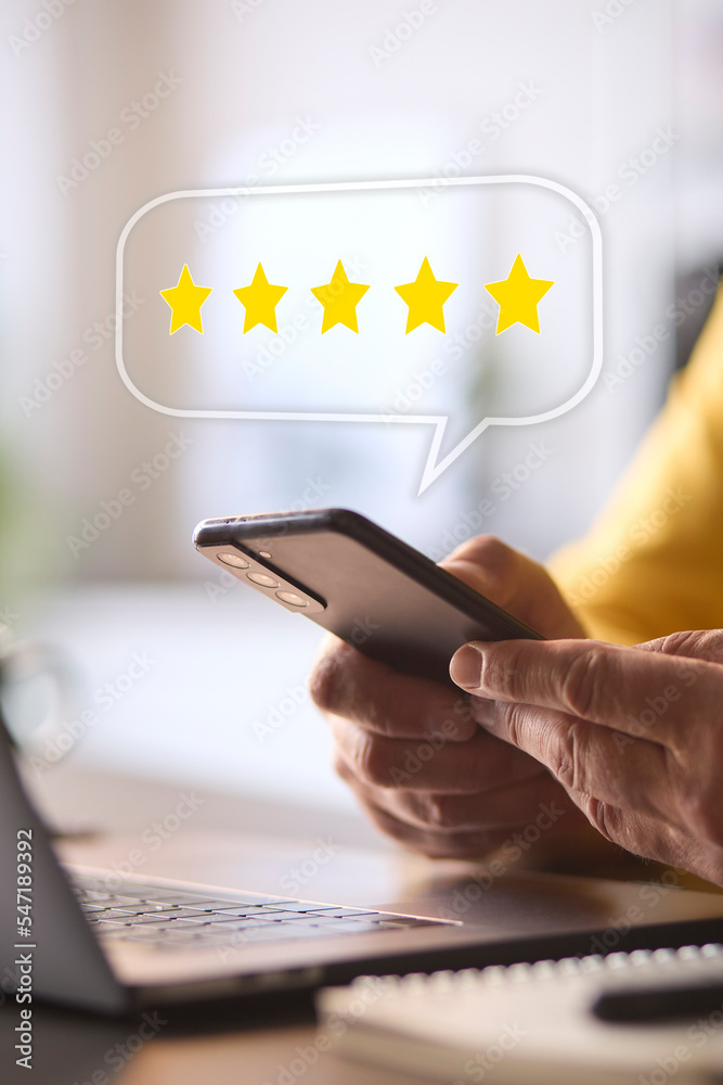 Wall mural man using mobile phone with graphic overlay to leave positive 5 star online review