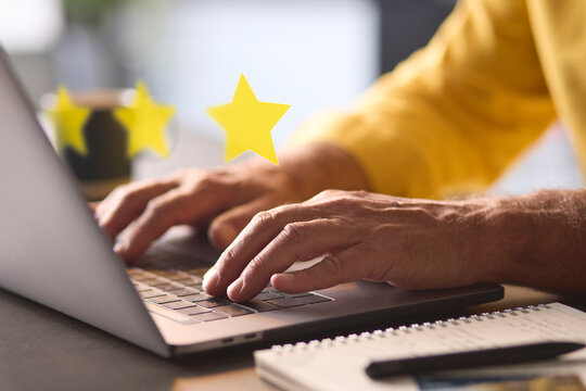 Man Using Laptop With Graphic Overlay To Leave Positive 5 Star Online Review