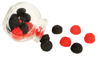 Sweet black and red fruit juice jellies in the shape of blackberries and raspberries pouring out of a jar.