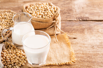 Soy milk in a glass with soybeans on a wooden table Organic breakfast, high protein, healthy,...