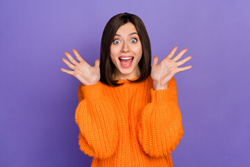 Photo portrait of gorgeous young woman raise arms excited scream dressed stylish knitted orange garment isolated on purple color background