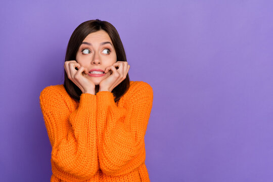 Portrait of frightened impressed lady biting finger nail look empty space isolated on purple color background