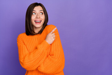 Portrait of positive charming girl look direct finger empty space promotion isolated on purple color background