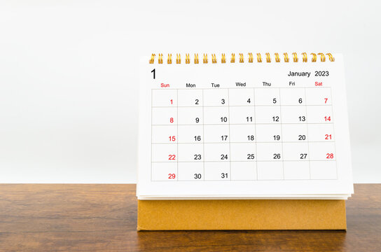 The January 2023 Monthly desk calendar for 2023 year on wooden table.
