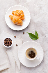 Coffee glass, roasted coffee beans and bread on the white table
