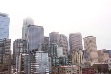 Fototapeta na wymiar Seattle, Washington, USA- October 4, 2022: Downtown Seattle skyline cityscape building viewed from the waterfront on a gloomy fog sky day
