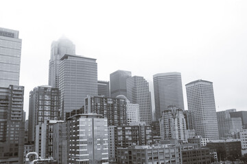 Fototapeta na wymiar Seattle, Washington, USA- Downtown Seattle unidentifiable buildings skyline cityscape building viewed from waterfront on gloomy fog sky day in black and white