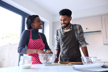 Couple At Home Baking Cake Together In Kitchen