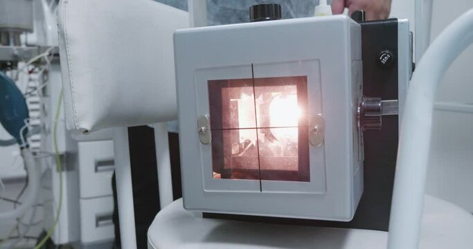Light x-ray machine lies on a chair. You can see how the X-ray apparatus glows all over the place. Portable x-ray ready for work lies in the operating room.