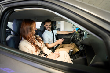 Couple choosing new vehicle in car dealership