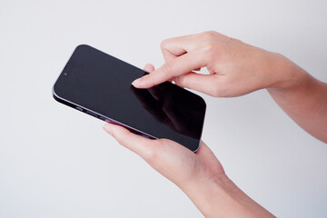 girl holding a smartphone touching the screen.