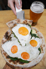 Eating pizza. Closeup view of a woman's serving a slice of pizza with mozzarella cheese, spinach and a fried egg.