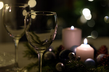 Serving the festive table. Food and drinks, plates and glasses. Evening lights and candles. Christmas dinner on Christmas Eve and New Year's Eve.