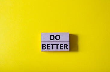 Do better symbol. Wooden blocks with words Do better. Beautiful yellow background. Business and Do better concept. Copy space.