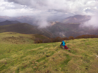 Fototapeta premium Hiker sitting on top of the mountain. Autumn in Belate