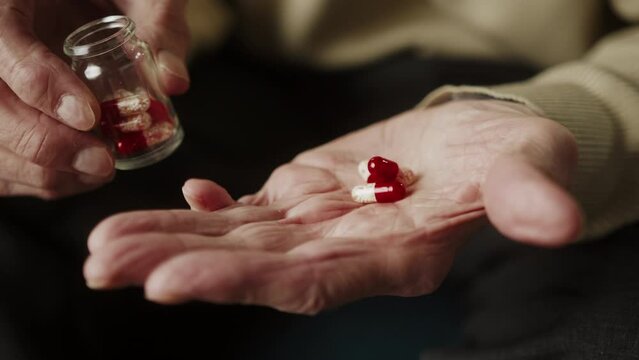 Man Hold Many Multi-colored Pills In A Senior's Hands, Antibiotic And Vitamin Drugs. Painful Old Age. Caring For The Health Of The Elderly, Nursing Home Hospital, Coronavirus Covid 19 Vaccination