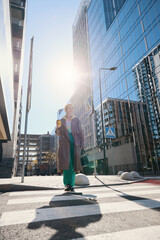 Joyful woman in comfortable shoes crosses street on pedestrian crossing