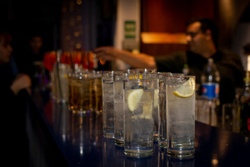 Vodka con limón en vasos sobre la barra del bar. Vasos de cocktail en perspectiva con bokeh.