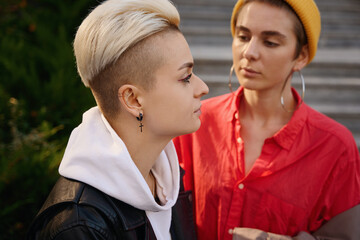 Blonde and brunette on city walk on warm autumn day