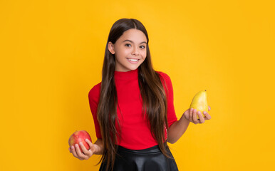 smiling child hold apple and pear on yellow background