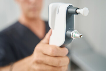 Close up photo of male doctor holding tonometer
