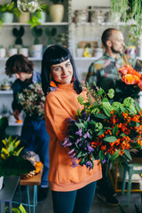 Woman working with florists in flower store