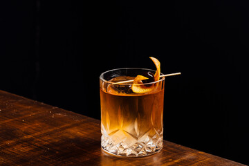 old fashioned cocktail on a wooden table and black background
