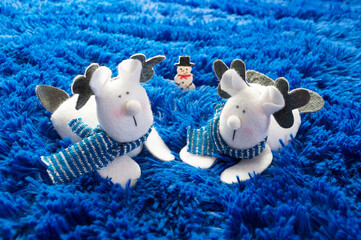 Two fabric reindeer and a plush blue snowman