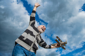 bearded senior man on sky background. senior man at retirement. senior retired man with toy plane