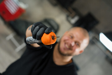 Tattoo studio interior - male tattoo artist showing a sterile tattoo machine