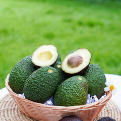 Whole and cut avocados on table. Space for text