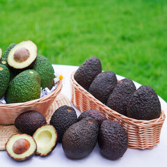 Whole and cut avocados on table. Space for text