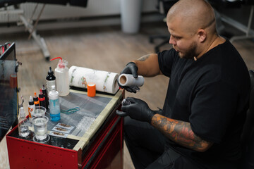 Tattoo artist collects tattoo washing machine. Tattoo needles