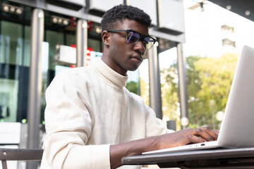 Serious black man working on netbook