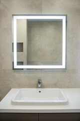 Bathroom interior with mirror and wash basin.
