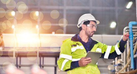 Professional engineer using tablet inspecting machine in factory