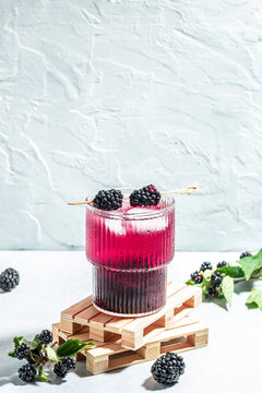 Refreshing lemonade with blackberry on a light background. vertical image. top view. place for text