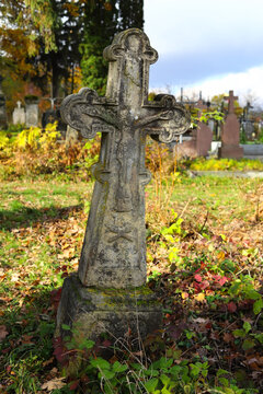 Old cemetery. Old neglected, mutilated figures of saints and crosses on graves. Remains of tombstones at a cemetery in Western Ukraine. Autumn sunny day.