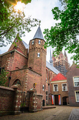 Fototapeta na wymiar Narrow street and Oude Kerk tower in old beautiful city Delft, Netherlands