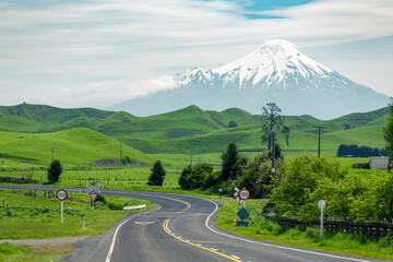 Country road with farm land and mountain