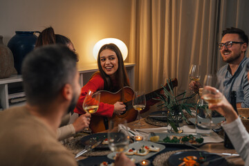 Girl plays the guitar and sings with friends