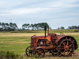 Fototapeta na wymiar Old rusty tractor set out in a field