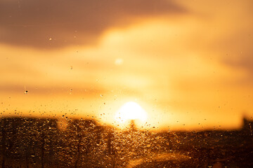 Sunset after rain. View through the window, with raindrops on the glass