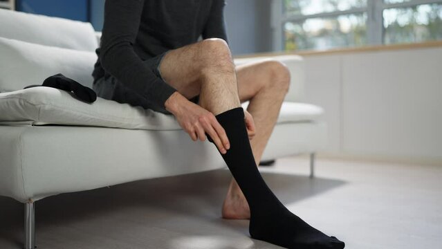 Man Putting On Medical Compression Stockings