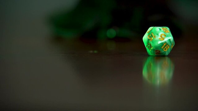 A green 20 sided dice rolling into view.