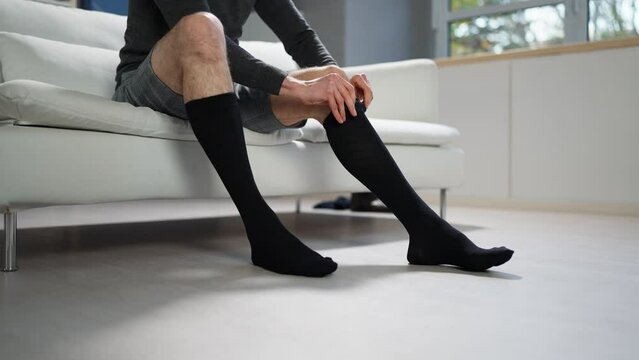 Man Putting On Medical Compression Stockings