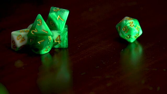 Rolling a green 20 sided dice into view.