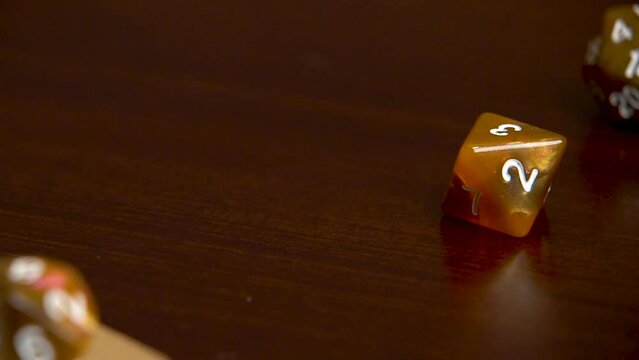 Rolling an orange 8 sided dice into view.