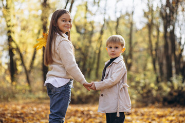 Brother with sister together in autumn park